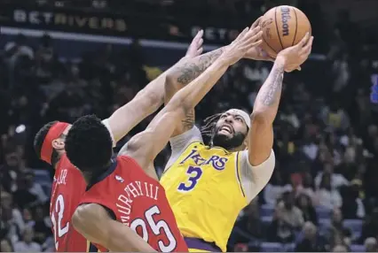  ?? Photograph­s by Matthew Hinton Associated Press ?? LAKERS FORWARD Anthony Davis, who had 35 points and 17 rebounds, shoots against the double team of New Orleans Pelicans forward Larry Nance Jr. (22) and guard Trey Murphy III. The Lakers had a season-high 75 points and led by 35 at halftime.