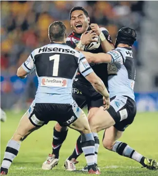  ??  ?? Stopped in tracks: Warriors centre Conrad Hurrell is tackled by Cronulla fullback Michael Gordon and halfback Jeff Robson.