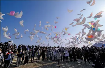  ??  ?? REMEMBER Left: A man in the ruins of his home in March 2011. Below: Releasing dove-shaped balloons on the 10th anniversar­y of the disaster that killed over 18,000 people.