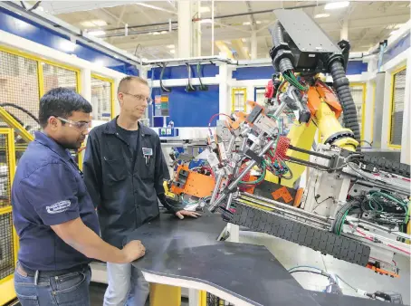  ?? JASON KRYK ?? Controls engineer Nanda Vandala, left, and electricia­n Michael Hunt check out manufactur­ing equipment at Reko Internatio­nal Group Inc., where the company announced Wednesday plans for an expansion to its Lakeshore plant. It is expected to be completed...