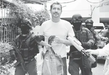  ??  ?? Justo is escorted by Thai police commandos as he arrives at the Immigratio­n Detention Centre in Bangkok.