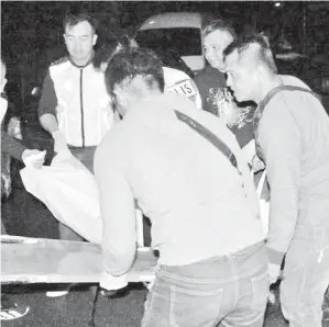  ??  ?? MAYAT mangsa diusung masuk ke dalam kenderaan polis untuk dihantar ke rumah mayat Hospital Sibu.