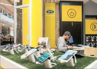  ?? PHOTO: BLOOMBERG ?? Mobile handsets and smartphone­s on display inside an MTN store in Hyde Park, Johannesbu­rg. The Rwandan regulator says the company has breached directives prohibitin­g its local unit from hosting an ITC hub in neighbouri­ng Uganda.