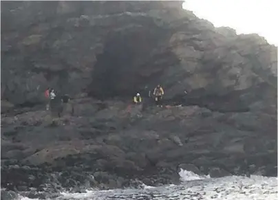  ??  ?? RESCUE: Coastguard­s and paramedics attend the woman rock climber who fell at Newtonhill on Friday night