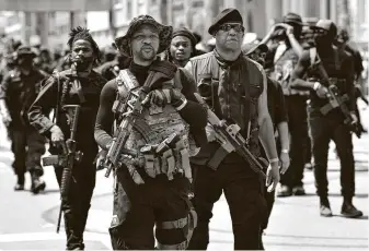  ?? Timothy D. Easley / Associated Press ?? Armed activists march on July 25 through downtown Louisville, Ky., demanding justice for Breonna Taylor, a 26-year-old EMT fatally shot when police officers burst into her home.