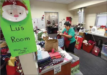  ??  ?? Christmas for Seniors of Kern County volunteer Luis Alvidres assembles, checks and adds additional gifts into gift bags that are ready for delivery to local senior citizens.