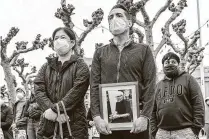  ?? Stephen Lam / San Francisco Chronicle ?? At a rally, Eric Lawson holds a photo of his late father-in-law, Vicha Ratanapakd­ee, who was killed in San Francisco.