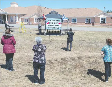  ?? ANDREW VAUGHAN / THE CANADIAN PRESS ?? Workers at an extended care facility show their community support in Debert, N.S., on Tuesday, after a shooting rampage across Nova Scotia on the weekend that saw 22 victims killed and the country shaken.
