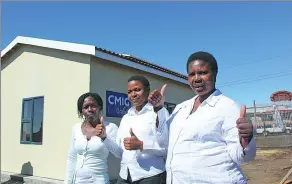  ?? PROVIDED TO CHINA DAILY ?? Local residents pose in front of the sample house built by CMIG Drawin.