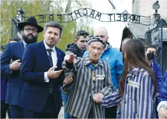  ?? (Kacper Pempel/Reuters) ?? HOLOCAUST SURVIVOR Edward Mosberg and his relatives take part in the annual Internatio­nal March of the Living through the grounds of the former Auschwitz death camp, in Oswiecim, Poland, last year.