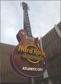  ?? The Associated Press ?? IT’S LIT: The giant replica electric guitar hangs outside the Hard Rock casino in Atlantic City, N.J. after it was illuminate­d on the casino’s first night of operation on Wednesday.
