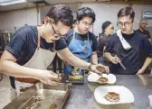  ??  ?? Chef Nicco Santos assists the Black Sheep team, led by chef Patrick Go, in plating their dish.