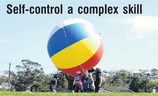  ?? PHOTO: ODT FILES ?? Cooperatio­n . . . Children play with a giant ball.