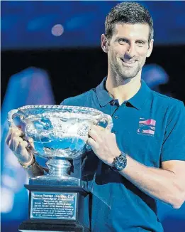  ?? Picture: AFP ?? FAVOURITE: Novak Djokovic poses with the men’s singles championsh­ip trophy during the draw announceme­nt ahead of this year’s Australian Open tennis tournament.