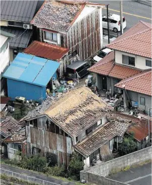  ??  ?? DAMAGE: Roof tiles fallen from a house lie scattered following the earthquake