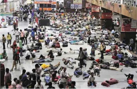  ?? —AP ?? AHMEDABAD: Indian passengers sleep as they wait for trains at a railway station in Ahmadabad. India has released new socio-economic and caste census data yesterday that covers the period between 2011 and 2013 to show the wealth, living conditions and...