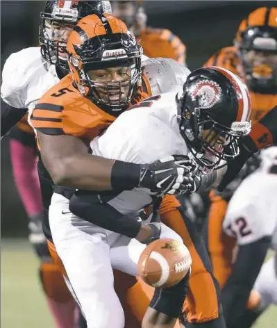  ?? Matt Freed/Post-Gazette ?? Beaver Falls' Donovan Jeter hasn’t wrapped up his college decision yet the way he wrapped up Aliquippa’s Sheldon Jeter last season, causing a fumble.