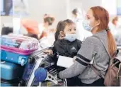  ?? AL SEIB/LOS ANGELES TIMES 2020 ?? Karen Alvarez and her 3-year-old daughter Mercedez Gomez wear face masks at Los Angeles Internatio­nal Airport before their flight to Nicaragua.