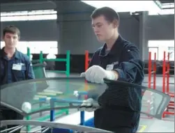  ?? ZHANG LINGYAN / XINHUA ?? Workers of Fuyao Group’s automobile glass plant in Kaluga, Russia, inspect a windscreen before dispatch. The Chinese company set up its first overseas plant in Russia in 2011 with a 1.33 billion yuan ($200 million) investment.