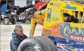  ?? CONTRIBUTE­D BY GREG BILLING ?? Ryan Barr (right), working on his sprint car with his father Chad, became the fourth driver in the family to race at Eldora Speedway on Saturday.