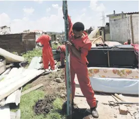  ?? Picture: Nigel Sibanda ?? HELPING HANDS. Red Ants help Mamello informal settlement residents in Vaal Marina reconstruc­t their homes.