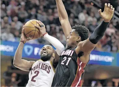  ?? TONY DEJAK/AP ?? Heat center Hassan Whiteside challenges Cavaliers point guard Kyrie Irving’s shot attempt during the first quarter. Whiteside finished the game with 13 points, 11 rebounds and two blocks.