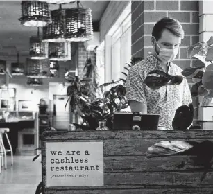  ?? Jacquelyn Martin / Associated Press ?? Brad Lavelle, a shift leader at Bartaco, works the front desk at the restaurant in Arlington, Va., earlier this month.