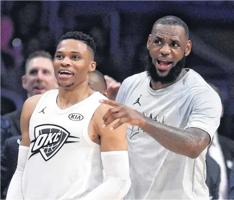  ?? [AP PHOTO] ?? Russell Westbrook, left, and LeBron James cheer from the bench during the first half of Sunday’s NBA All-Star basketball game in Los Angeles.