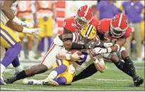  ??  ?? Georgia defensive lineman Malik Herring (10) and defensive back J.R. Reed (20) hit LSU quarterbac­k Joe Burrow (9) during an NCAA college football game for the Southeaste­rn Conference championsh­ip Saturday in Atlanta.