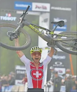 ??  ?? Nino Schurter levanta su bicicleta en meta para celebrar su triunfo.
