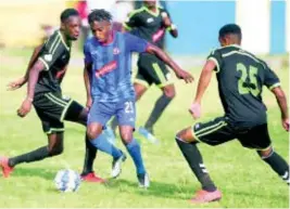  ?? RICARDO MAKYN ?? Molynes United player Jermey Nelson (left) and his teammate Orane Ferguson (right) challenge Dunbeholde­n’s Nickoy Christian for the ball during their Red Stripe Premier League match at the Constant Spring Football Football Field on December 29, 2019.