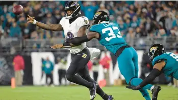  ?? NFL RAVENS PHELAN M. EBENHACK/AP ?? Baltimore Ravens quarterbac­k Lamar Jackson gets a pass away as he is pressured by Jacksonvil­le Jaguars linebacker Devin Lloyd on Sunday. Jackson is in the running for his second NFL Most Valuable Player award.