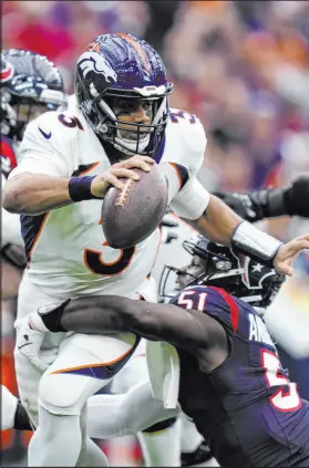  ?? Eric Christian Smith The Associated Press ?? Broncos quarterbac­k Russell Wilson had a rough day against the Texans, getting sacked three times and throwing three intercepti­ons.