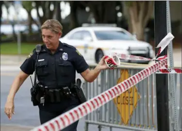  ?? JOHN RAOUX — ASSOCIATED PRESS ?? A Jacksonvil­le, Fla., police officer on Monday blocks off an area near the scene of Sunday’s fatal shootings.