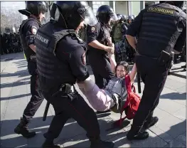  ?? PHOTOS: ALEXANDER ZEMLIANICH­ENKO — THE ASSOCIATED PRESS ?? Police officers detain a woman Saturday in the center of Moscow during an unsanction­ed rally protesting upcoming city elections.