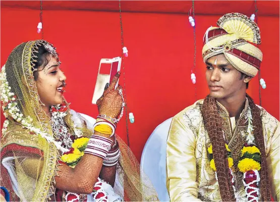  ??  ?? Bitte lächeln! Viele indische Brautleute lernen einander erst bei der Hochzeit wirklich kennen. Ein Großteil der Ehen auf dem Subkontine­nt
wird immer noch von den Eltern arrangiert.