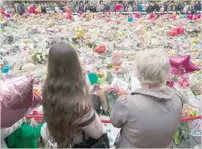  ?? — AFP ?? People at St Ann’s Square in Manchester, northwest England, placed in tribute to the victims at the Manchester Arena.