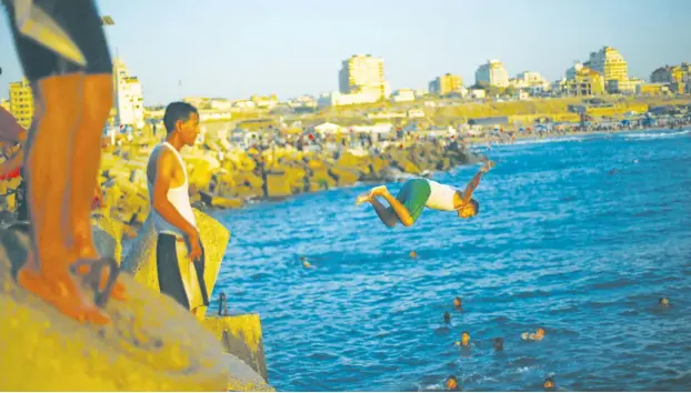  ?? (Reuters) ?? CHILDREN JUMP into the sea in Gaza.