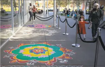  ?? Jessica Christian / The Chronicle ?? Rangoli patterns, a form of Indian folk art celebratin­g art, beauty and culture, were created outside Bishop Ranch City Center in San Ramon to celebrate the Hindu holiday Diwali.