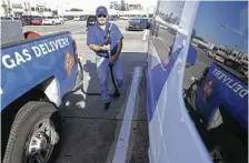  ?? Melissa Phillip / Staff photograph­er ?? Bobby Perry with Yoshi gas delivery fills up a commuter van Friday. Exxon Mobil invested $4 million in Yoshi, which charges members $20 a month plus the cost of the gas.