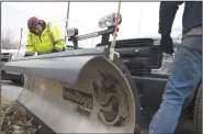  ?? NWA Democrat-Gazette/CHARLIE KAIJO ?? Operators Ricky Clanton (left) and Patrick Clanton (right) install a snow plow to a truck Friday at Benton County’s Road Department in Bentonvill­e. The Road Department prepared their trucks for a winter storm expected to hit the area this weekend. Rain is expected to move over to snow.