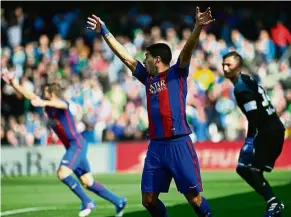  ??  ?? Show of hands: Barcelona’s Luis Suarez (centre) gesturing to the referee after the ball crossed the goal line in the match against Real Betis on Sunday. — AFP