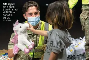  ?? GETTY/MOD ?? Gift: Afghan girl is given a toy on arrival at RAF Brize Norton in the UK