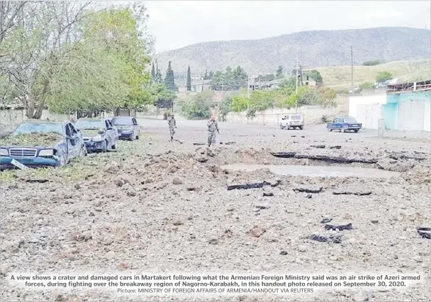  ?? Picture: MINISTRY OF FOREIGN AFFAIRS OF ARMENIA/HANDOUT VIA REUTERS ?? A view shows a crater and damaged cars in Martakert following what the Armenian Foreign Ministry said was an air strike of Azeri armed forces, during fighting over the breakaway region of Nagorno-Karabakh, in this handout photo released on September 30, 2020.