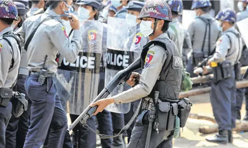  ?? PHOTO: REUTERS. ?? Crowd control:
A police officer during a protest against the military coup in Naypyitaw, Myanmar.