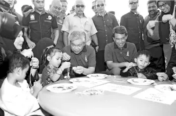  ?? - Bernama photo ?? Zahid and Menteri Besar of Negeri Sembilan Datuk Seri Mohamad Hasans pending time with children at the ‘Ekspresi Negaraku’ programme.