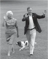  ?? Associated Press ?? n This Aug. 24, 1992, file photo shows President Bush, right, and first lady Barbara Bush walking with their dog Millie across the South Lawn as they return to the White House.