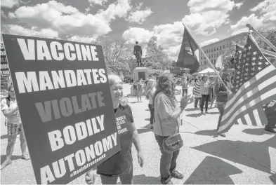  ?? JOSEPH PREZIOSO/GETTY-AFP ?? Demonstrat­ors hold signs protesting vaccines at the “World Wide Rally for Freedom,” an anti-mask and anti-vaccine rally at the State House in Concord, New Hampshire, on May 15.