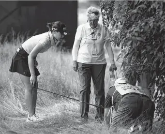  ?? Nick Wass/Associated Press ?? South Korea’s In Gee Chun, left, looks for her ball in the rough on the 16th hole during the third round. Chun entered with a six-shot lead, but a shaky round cut her advantage in half.