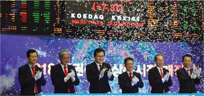  ??  ?? SEOUL: South Korea’s Financial Services Commission chairman Choi Jong-Ku (third left) and officers celebrate the New Year’s opening of the stock market at the Korea Exchange in Seoul yesterday.